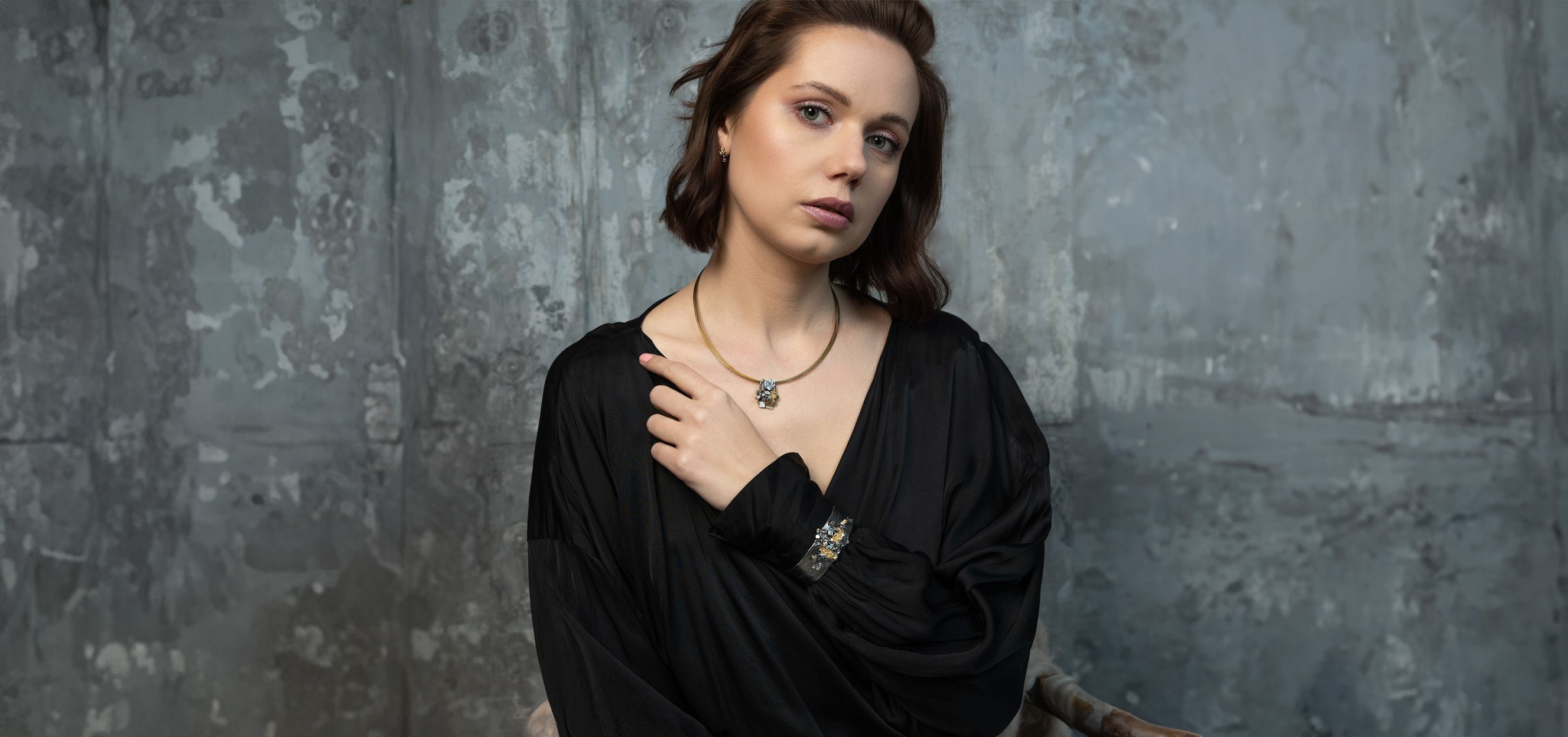Hauptfoto-brünette Frau mit schönem Armband, Auf einem grauen  Hintergrund